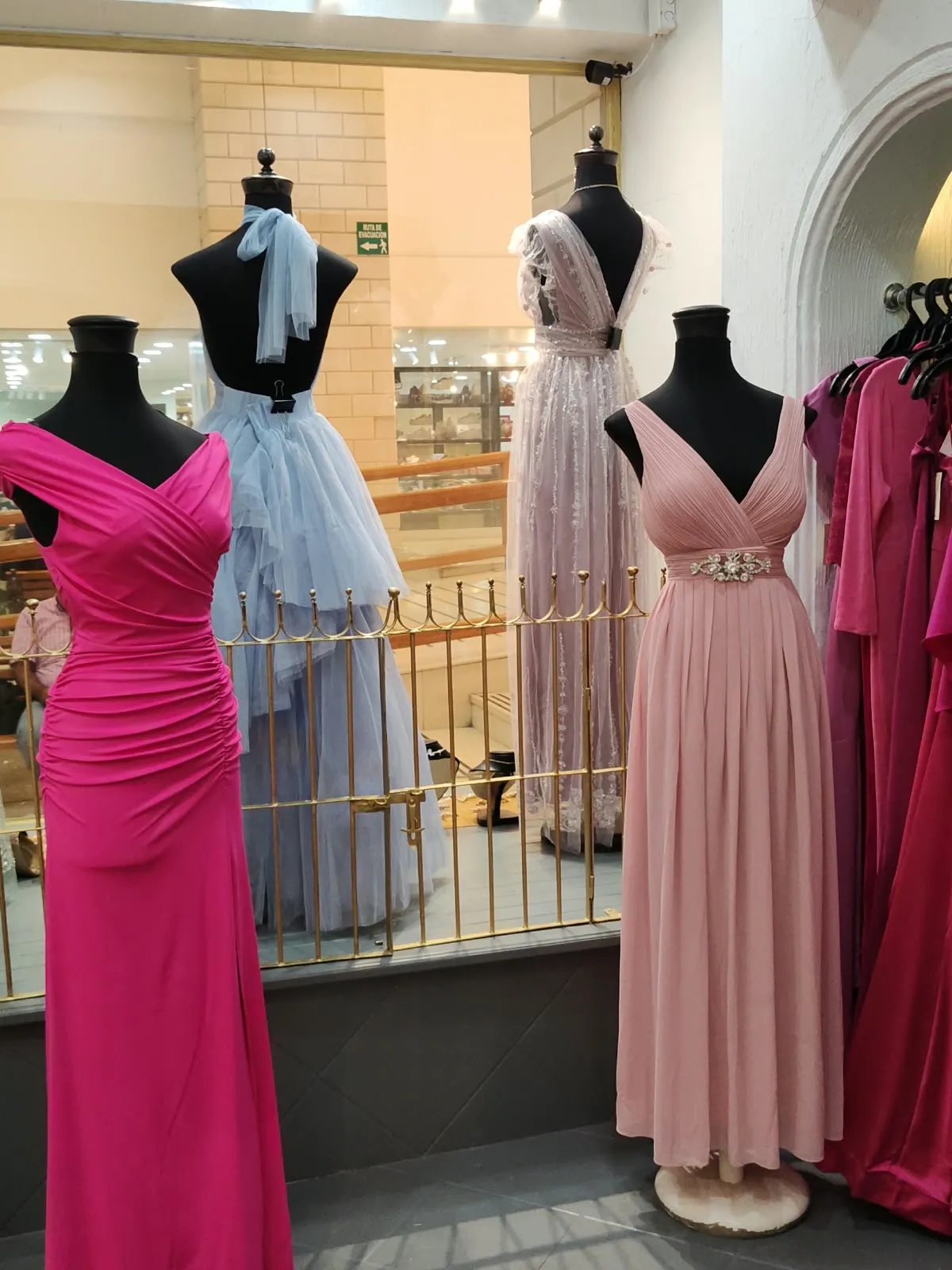 Vestidos largos fucsia, rosa palo y azul cielo en maniquí