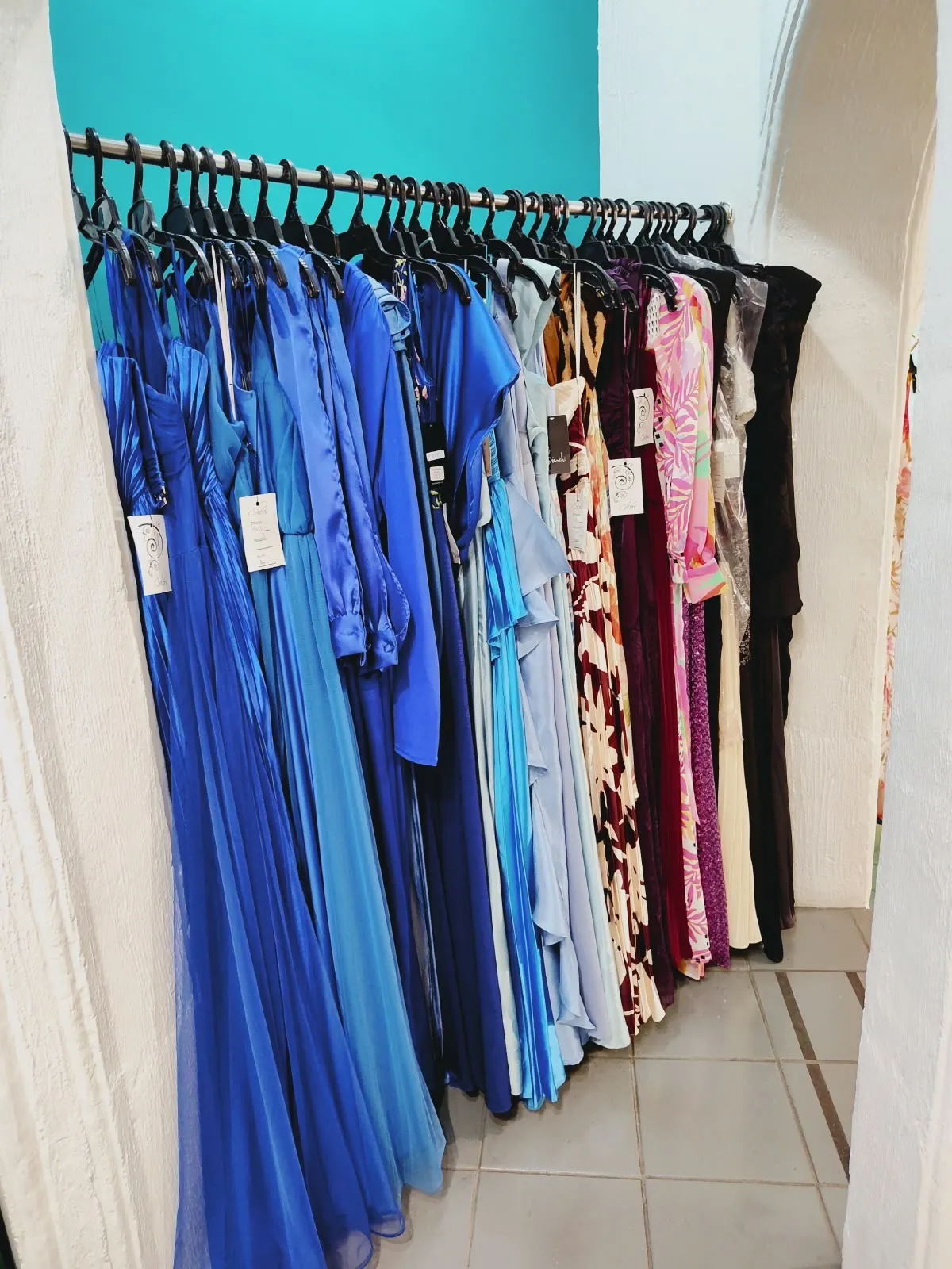 Perchero con vestidos largos en muchos tonos de azul, además de estampados, vino y negro